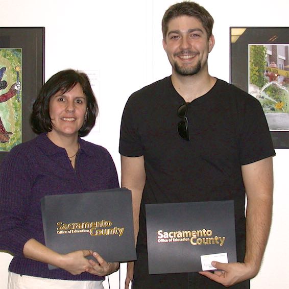 Organizers holding stacks of certificates to be presented to artists
