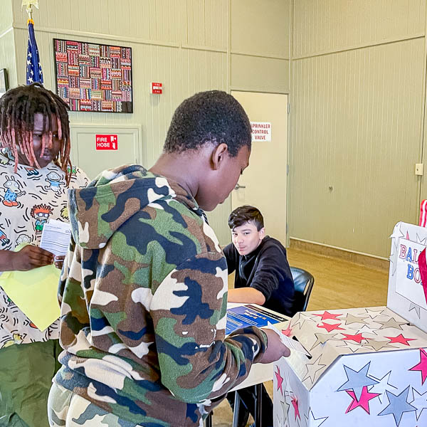 Student putting ballot into box