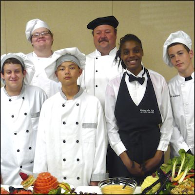 Teacher and students wearing culinary uniforms