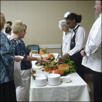 Students serving healthy food to staff