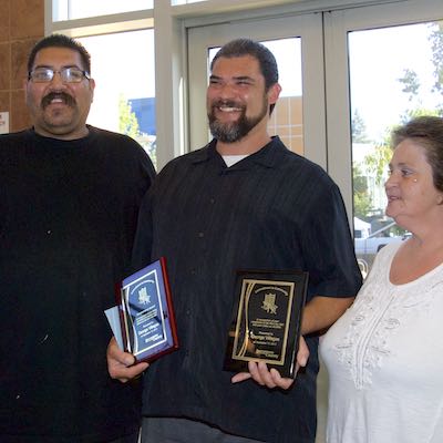 Honoree standing with family, holding plaques