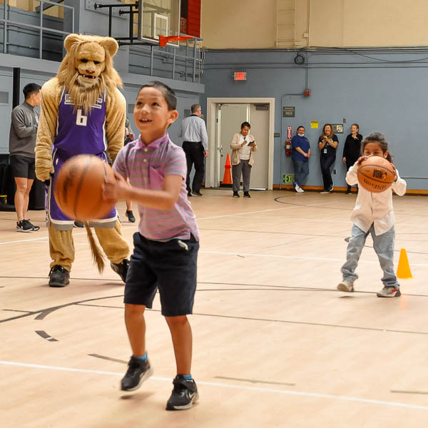 Slamson helping students shoot baskets