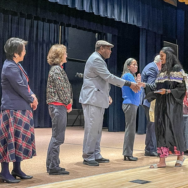 Officials shaking hands with graduates