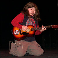 Student kneeling and pretending to play a guitar