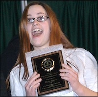Smiling student poses with her plaque