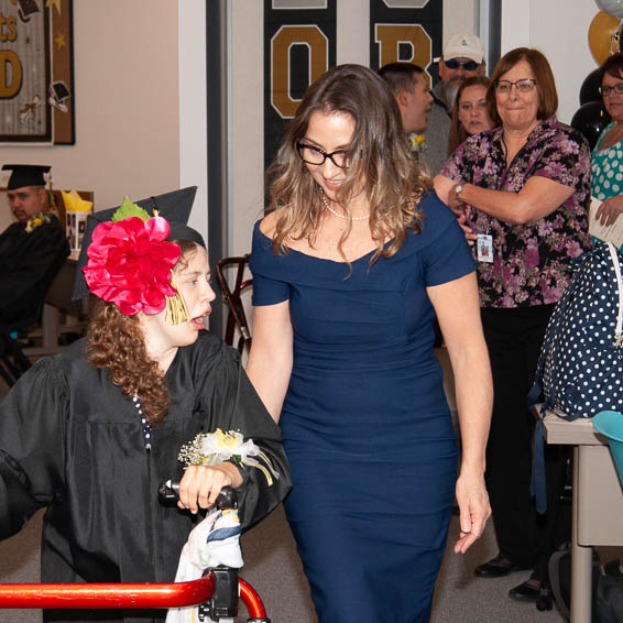 Graduate walking with assistive device