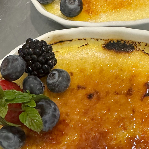 Close-up photo of crème brûlée with berries on top