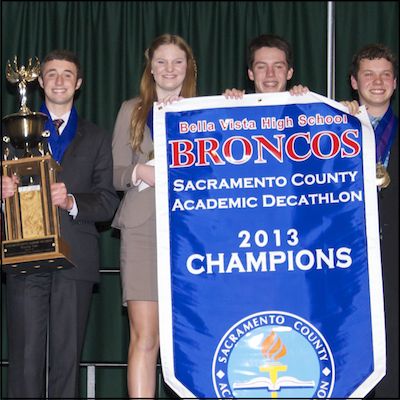 Students holding trophy and 2013 champions banner