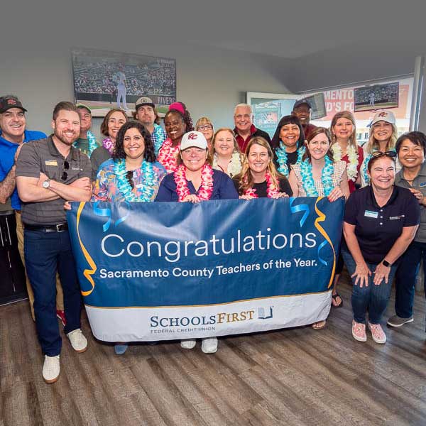 Teachers posing with SchoolsFirst congratulations banner