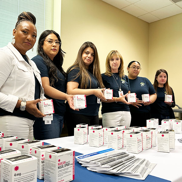 Prevention & Early Intervention staff holding boxes of Narcan