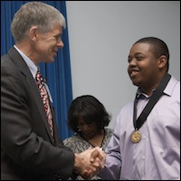 Greg Geeting shaking hands with student