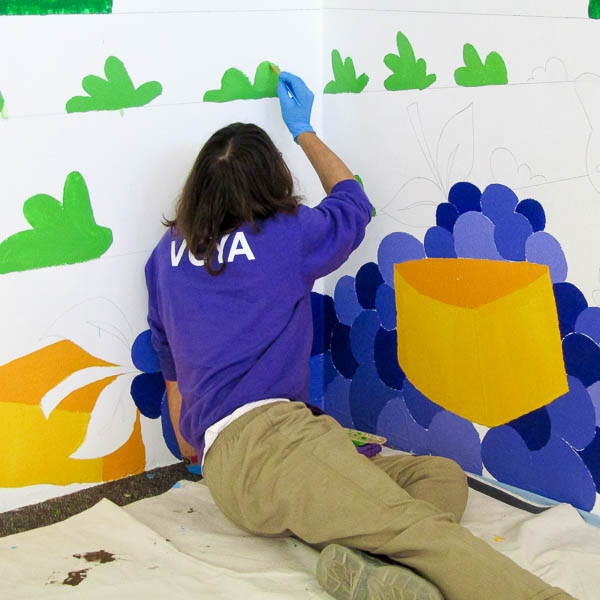 Student seated on the floor painting