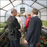 Kevin Jordan showing visitors plants inside a greenhouse
