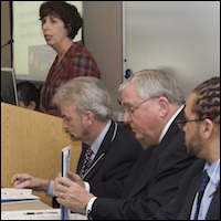 Panel members sitting next to speaker