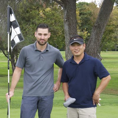 Golfers standing by checkered flag