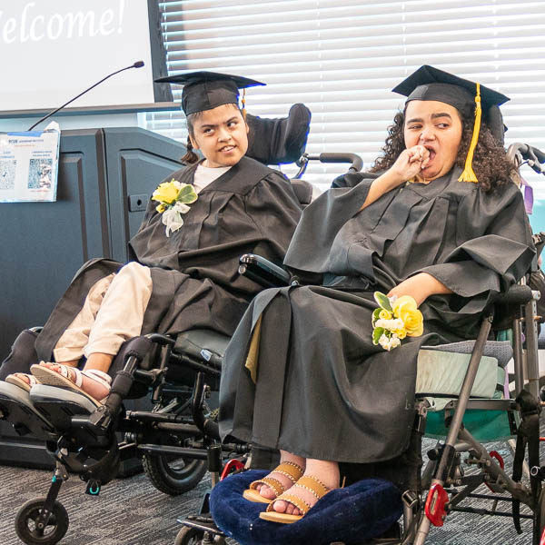 Graduates using wheelchairs seated side by side