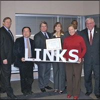 Board trustees holding metal 'LINKS' sign