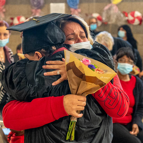 Emotional parent happily hugging graduate