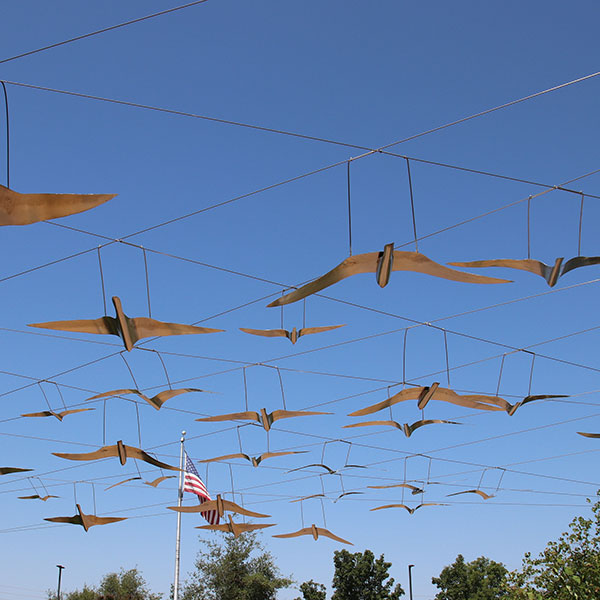 Metal bird sculptures hanging from wires