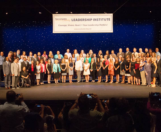 Large group photo of graduating class standing on stage