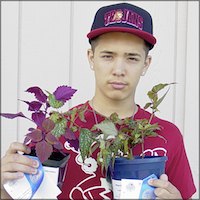 Student holding plants and award ribbons