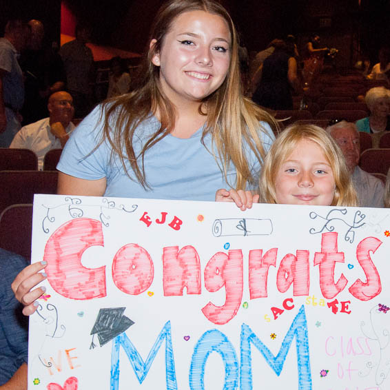 Children holding 'congrats mom' sign
