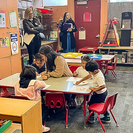 Visitors observing children in classroom