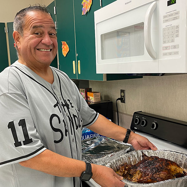 Louie Godinez holding a cooked turkey in a pan