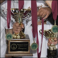 Students holding medals and trophy