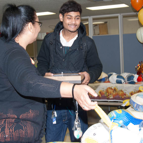 Student holding pie receives a frozen turkey