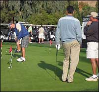 Golfer putting while others watch