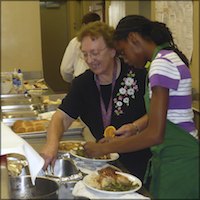 Instructor helping student serve food