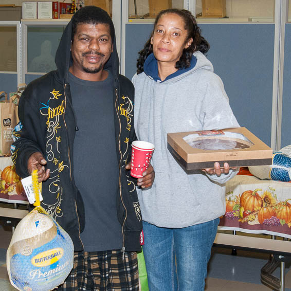 Family members holding donated turkey and pie