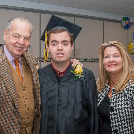 Graduate posing with parents