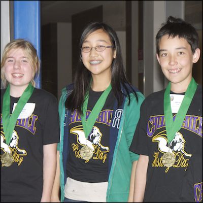 Three students wearing medals