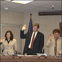 Sylvia Ruiz, Christopher Woods, and Elinor L. Hickey with raised hands, taking oath of office